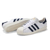 A pair of white and navy ADIDAS X POP TRADING CO. SUPERSTAR ADV sneakers, perfect for skateboarding or showing support for the New England Revolution.