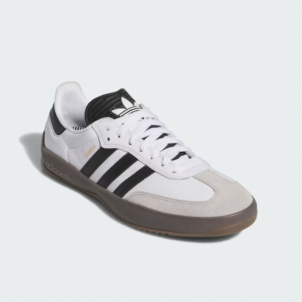 An ADIDAS PUIG SAMBA ADV CLOUD WHITE / CORE BLACK / GUM shoe, featuring black stripes, white laces, an EVA midsole, and a gray and gum sole, is displayed against a plain light background.