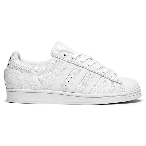 The ADIDAS X VITORIA MENDONCA SUPERSTAR ADV in Core White / White Reflective boasts a suede upper with a textured pattern and the iconic three-stripe design. Its flexible cupsole construction combines style and comfort seamlessly.