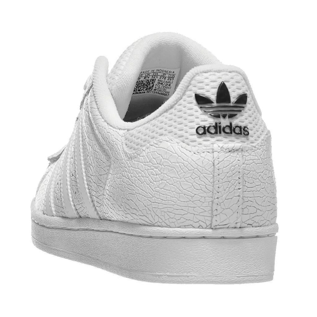 The ADIDAS X VITORIA MENDONCA SUPERSTAR ADV in Core White/White Reflective showcases a textured leather and suede upper with the iconic black trefoil logo prominently displayed on the heel, viewed from the back. Its flexible cupsole ensures both comfort and support, making it a perfect blend of style and functionality.