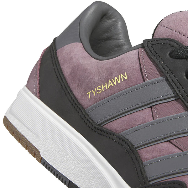 Close-up of the ADIDAS TYSHAWN 2 NIGHT FIG / GREY / BLACK skateboarding shoes featuring the name "Tyshawn" in gold lettering on the side, with a grey and black striped design on a purple suede background and a white cupsole construction.