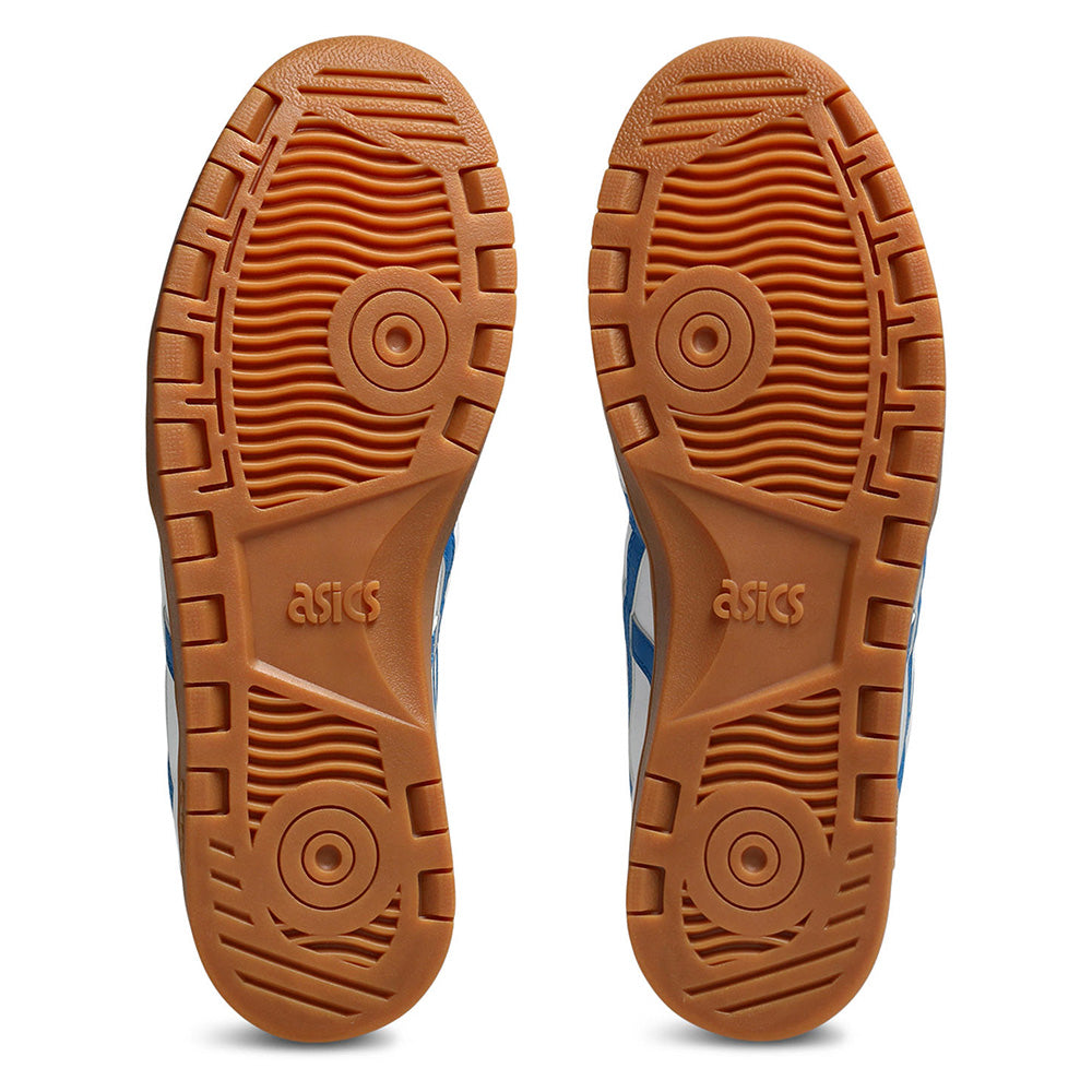 Pair of ASICS JAPAN PRO WHITE / DIRECTIORE BLUE skate shoe soles shown from the bottom, featuring circular grip patterns and durable tread design, set against a white background to highlight superior durability.