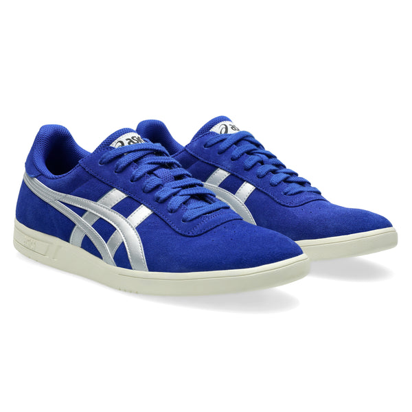 A pair of blue athletic sneakers with silver stripes and white soles, shown from a slight angle, these ASICS GEL-VICKKA PRO PRUSSIAN BLUE / PURE SILVER shoes bring style and performance together.