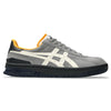 The ASICS VIC NBD CLAY GREY / BIRCH sneaker from ASICS boasts FF BLAST cushioning for exceptional comfort, presenting a gray and black design with white accents and an orange collar, captured from a side angle.