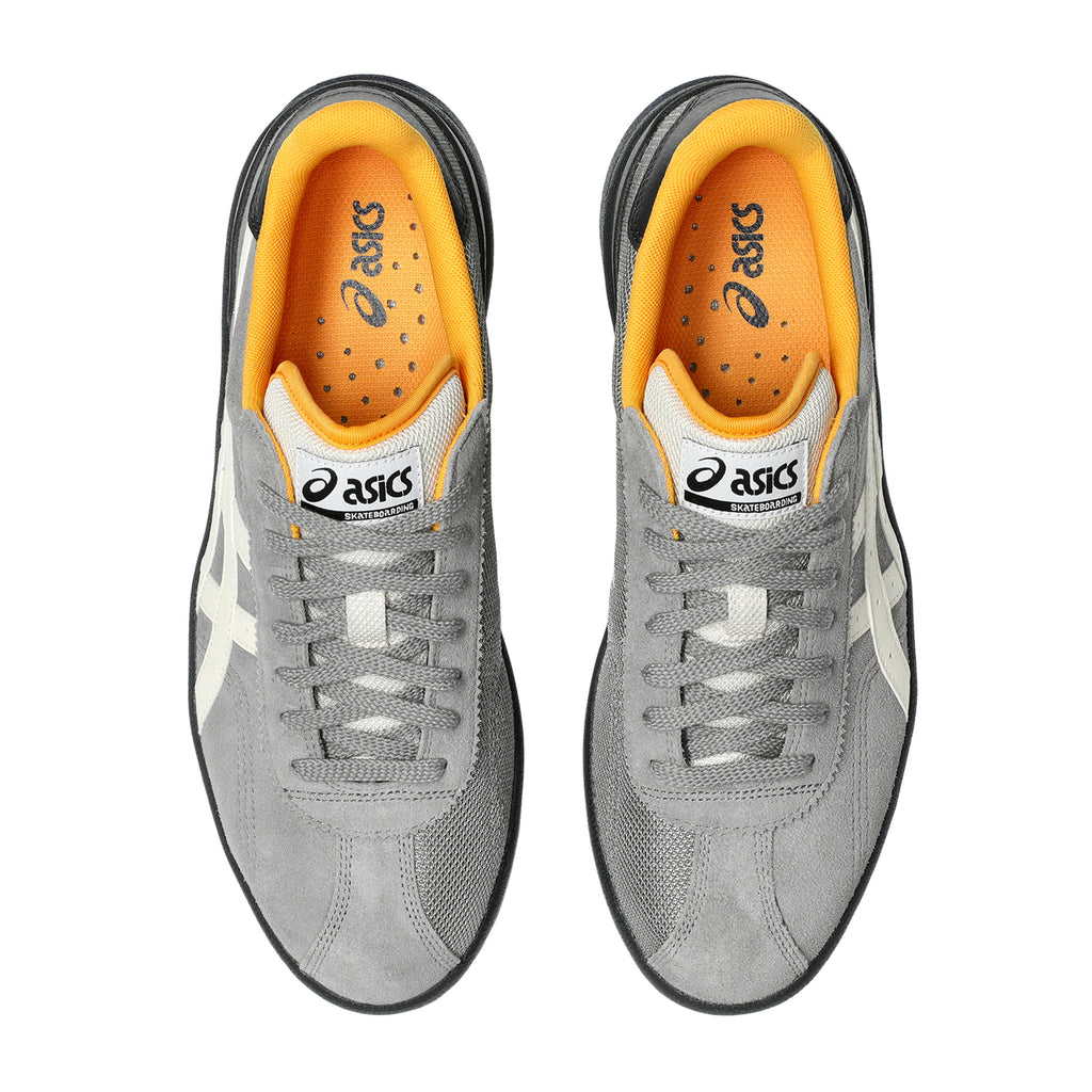 A pair of ASICS VIC NBD sneakers in Clay Grey and Birch, showcasing an orange inner lining and crafted from mesh and suede materials, viewed from above.