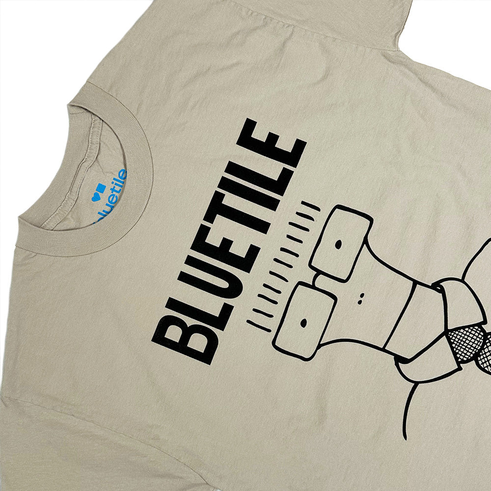 The BLUETILE NEVER GO TO COLLEGE TEE BONE by Bluetile Skateboards features a black cartoon character in a tie under bold "BLUETILE" lettering, crafted from heavyweight cotton for lasting comfort.