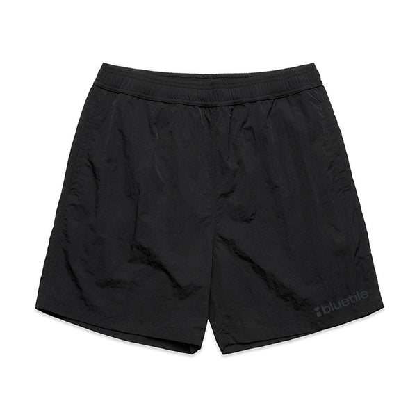 BLUETILE LOGO SWIM SHORTS BLACK by Bluetile Skateboards feature quick-dry recycled nylon, an elastic waistband, and a small BLUETILE LOGO on the lower left leg, shown on a white background.