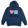 Introducing the "BLUETILE CHENILLE HEART & SQUARE HOODIE SEASIDE" by Bluetile Skateboards, a stylish navy blue hoodie made from eco-friendly organic cotton. It showcases a pink heart and blue square design, with "Bluetile" elegantly printed beneath the shapes. The garment-dyed fabric enhances its unique appeal.