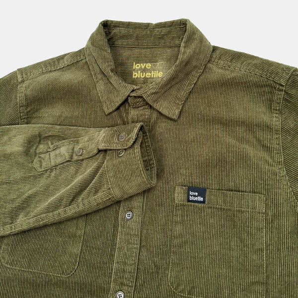 A Bluetile Skateboards "LOVE BLUETILE" corduroy button up army shirt with a small patch on it.