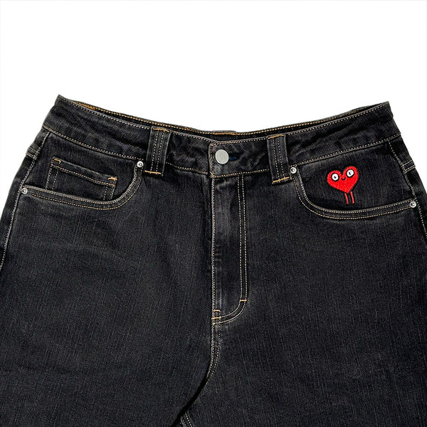 The BLUETILE BRAND DENIM RUTLEDGE PANT BLACK by Bluetile Skateboards features yellow stitching, a red heart patch with eyes on the right coin pocket, a loose fit, and an adjustable waist for comfort and style.