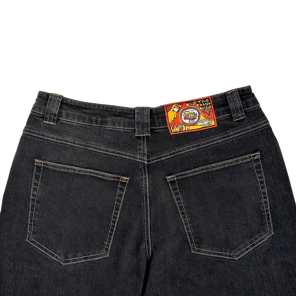 Back view of BLUETILE BRAND DENIM RUTLEDGE PANT BLACK by Bluetile Skateboards showing a loose fit, two rear pockets, and a colorful rectangular brand patch on the waistband.