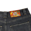 Back view of the BLUETILE BRAND DENIM RUTLEDGE PANT BLACK by Bluetile Skateboards, featuring a colorful embroidered "BLUETILE CANNA DENIM" patch with cartoon graphic above the waistband.
