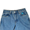 The BLUETILE BRAND DENIM RUTLEDGE PANT BLUE by Bluetile Skateboards features a small blue cartoon face patch above the right pocket, a drawstring adjustable waist, and is shown on a white background.