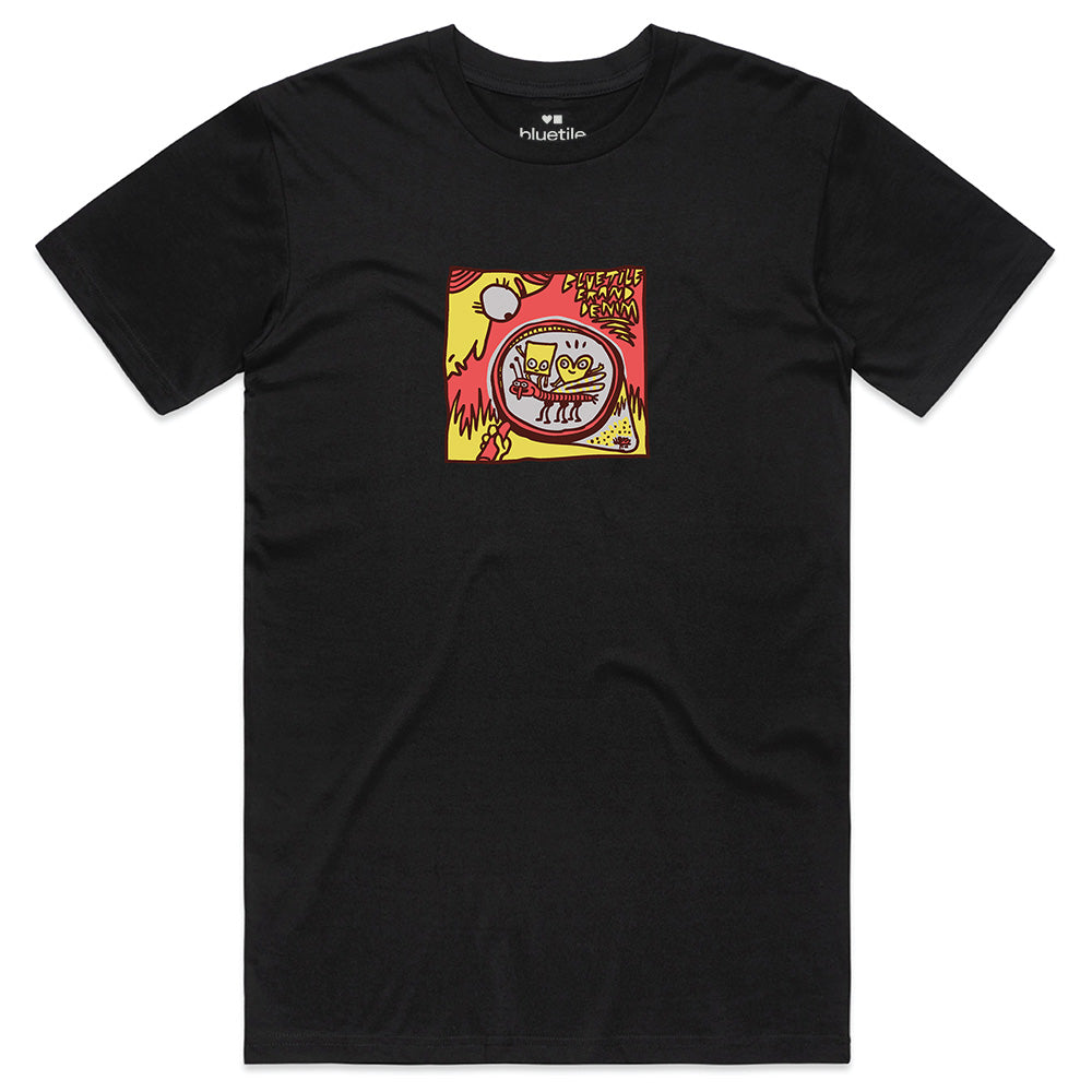 The BLUETILE DENIM BRAND TEE BLACK by Bluetile Skateboards is made from 100% combed cotton and features a vibrant cartoon cat graphic in a red circle with bold yellow and red accents, plus text above. Perfect with your favorite BLUETILE denim.