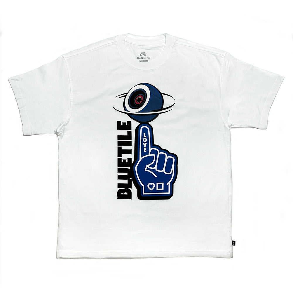 The BLUETILE NAVY FOAM FINGER TEE WHITE by Bluetile Skateboards features a blue eyeball, an upward navy foam finger with "BLUETILE" vertically and "LOVE" horizontally, all crafted from heavyweight cotton for ultimate comfort.