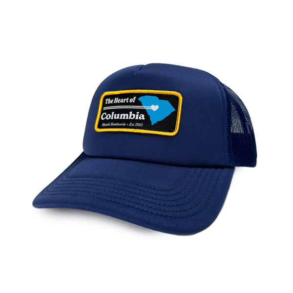 A BLUETILE "HEART OF COLUMBIA" TRUCKER COBALT hat with the word Bluetile Skateboards on it.