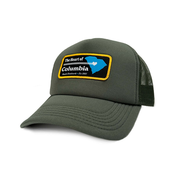 A BLUETILE "HEART OF COLUMBIA" TRUCKER CYPRESS hat by Bluetile Skateboards with a patch on it.