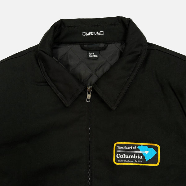 A black jacket with a patch on it featuring the Bluetile Skateboards logo.