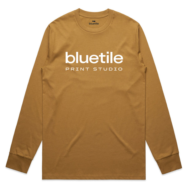 Introducing the BLUETILE PRINT STUDIO LONG SLEEVE CAMEL by Bluetile Skateboards, a brown long-sleeve tee crafted from 100% combed cotton for maximum comfort and style, featuring "Bluetile Print Studio" elegantly printed in crisp white on the front.