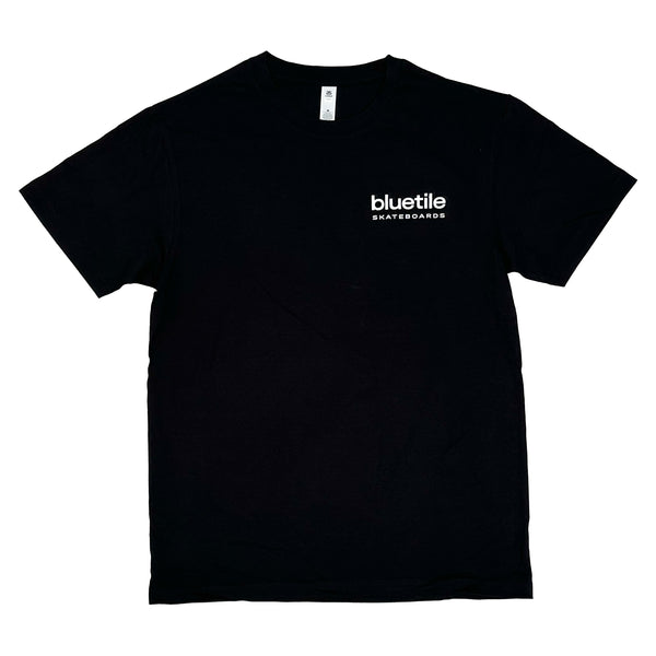 The BLUETILE X SKATE SHOP DAY STORE FRONT TEE BLACK, by Bluetile Skateboards, is a mid-weight cotton shirt featuring the "Bluetile Skateboards" logo in crisp white text on the upper left chest, ideal for fans of their favorite skate shop.