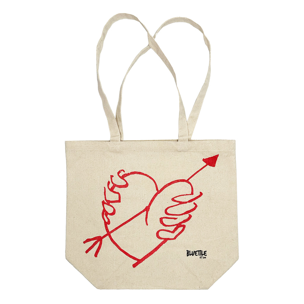 A BLUETILE "STUPID'S ARROW" TOTE bag with a heart and an arrow drawn on it. (Brand: Bluetile Skateboards)