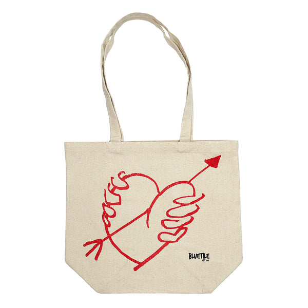 A BLUETILE "STUPID'S ARROW" tote bag by Bluetile Skateboards with a heart and an arrow drawn on it.