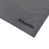 A close-up of the BLUETILE LOGO SWIM SHORTS SHADOW by Bluetile Skateboards shows the gray quick-dry fabric with "bluetile" and a black heart logo printed on the corner.