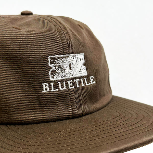 A brown hat with the word BLUETILE "RAZOR" CLASSIC HAT WALNUT on it.