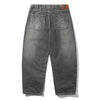 The Butter Goods Roach Denim Jeans Black Wash are shown flat from the back, with embroidered designs on both pockets, a brown leather patch on the waistband, and a signature baggy fit.