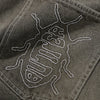 Close-up of black denim fabric with a white embroidered insect outline on the pocket—a signature detail from Butter Goods seen on their Roach Denim Jeans Black Wash.
