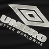 Close-up of the Umbro logo on black fabric, with the text "Utter Worldwide" beneath, similar to the style found in a Butter Goods x Umbro Diamond Logo Tee Black.