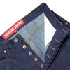 The CARPET CO. C-STAR JEANS RAW DENIM blue jeans by Carpet Co. are crafted from 100% cotton raw denim, featuring a partially buttoned fly and a visible "Star Jeans" label on the waistband for ultimate comfort and style.