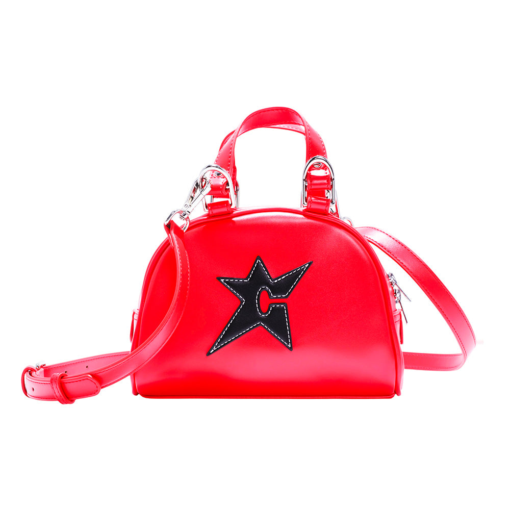 The Carpet Co. C-Star Purse Red features a bright red design with a top handle, shoulder strap, and a black star-shaped cutout patch on the front.