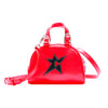 The Carpet Co. C-Star Purse Red features a bright red design with a top handle, shoulder strap, and a black star-shaped cutout patch on the front.