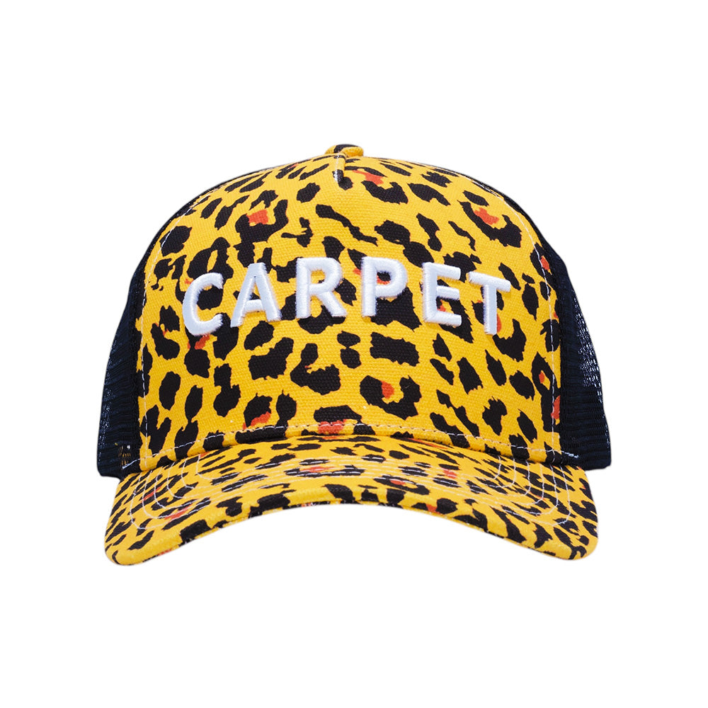 The Carpet Co. Trucker Cheetah hat features yellow and black cheetah embroidery, "CARPET" in white on the front, and a breathable mesh back.