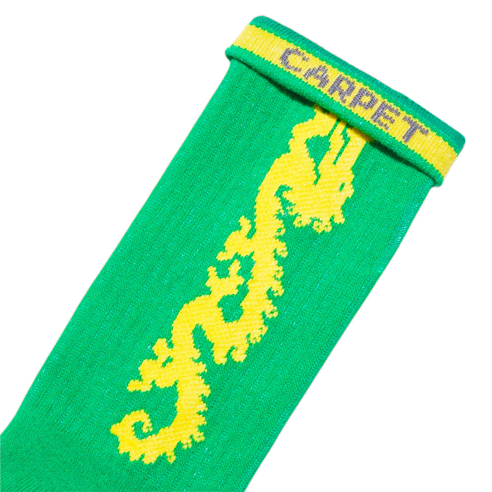 The STANCE CARPET CO. DRAGON SOCK GREEN features bold custom artwork—a yellow dragon and "CARPET" knit in yellow and purple on the cuff—set against a vibrant green background.