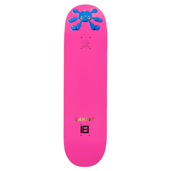 The CARPET BACTERIA skateboard deck by Carpet Co. showcases a striking bright pink deck with a blue abstract design at the top and the words "CARPET COMPANY" in gold letters near the bottom, blending vibrant base colors for an eye-catching look.