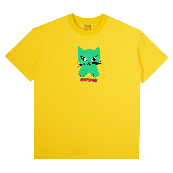 The CARPET CO. CAT TEE YELLOW by Carpet Co. is a yellow cotton tee with a green cartoon cat, black whiskers, and "carpet" printed below in pink and red letters.