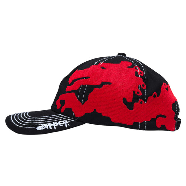 The CARPET CO. DRAGON HAT BLACK by Carpet Co. features a black snapback, bold red abstract side pattern, crisp white bill stitching, and a white embroidered signature inspired by the brand’s Dragon Hat design.