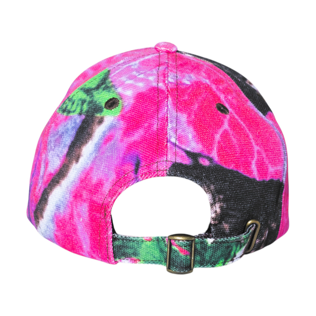 The CARPET CO. REALTREE HAT PINK by Carpet Co. features a vibrant tie-dye design with pink, purple, green, and black shades visible from the back, complete with an adjustable strap and buckle.