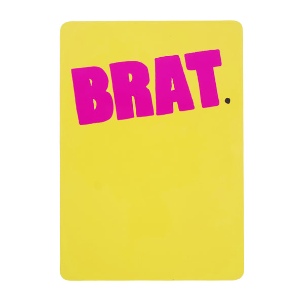 A bright yellow card with the word "CARPET CO. BRAT DVD" printed in bold pink letters at the center, featuring a strap back design by Carpet Co.