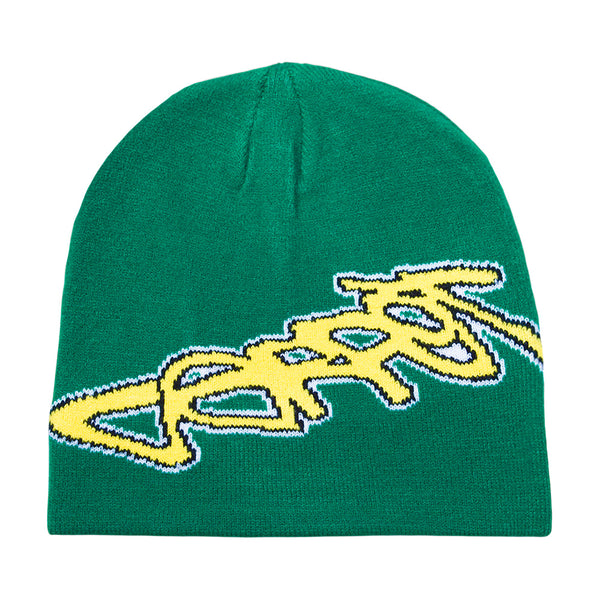 The CARPET CO. FREESTYLE BEANIE GREEN by Carpet Co. is a green cotton beanie featuring a large yellow and white stylized graphic text on the front in signature freestyle beanie style.