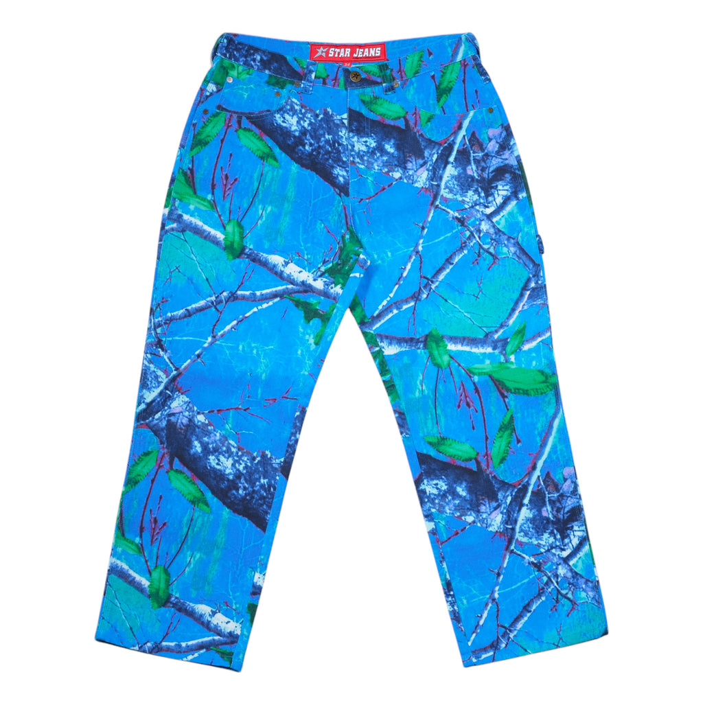 The CARPET CO. REALTREE PANT BLUE by Carpet Co. features a nature-inspired pattern with green leaves and branches, designed in collaboration with C-Star.