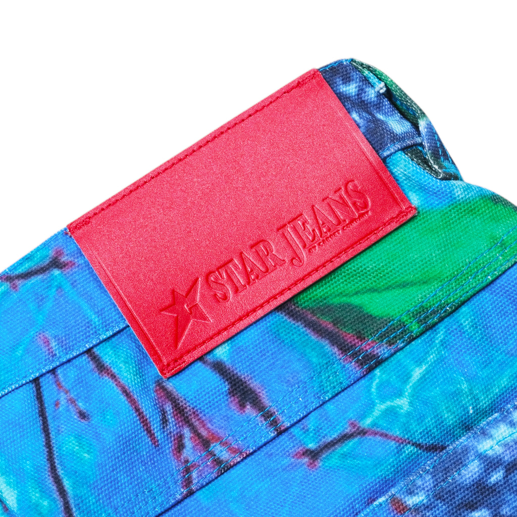 Close-up of a colorful fabric featuring a vivid red label that says "Carpet Co.," reminiscent of the dynamic patterns often found in Realtree designs, as seen on the Carpet Co. Realtree Pant Blue.