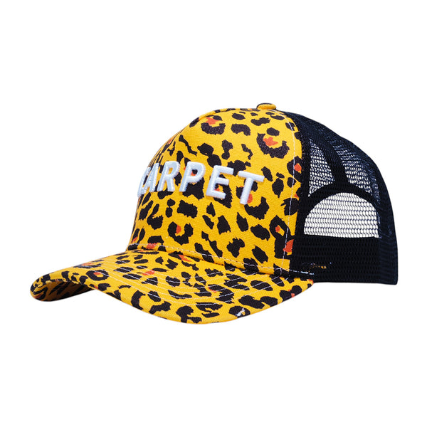 The CARPET CO. TRUCKER CHEETAH by Carpet Co. is a yellow and black mesh-back trucker hat featuring cheetah embroidery and bold white "CARPET" lettering on the front.