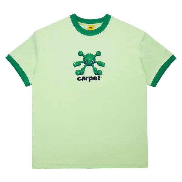 The Carpet Co. CARPET BACTERIA RINGER TEE GREEN is a light green ringer tee with dark green trim, showcasing an illustrated, multi-limbed character and the word "carpet" printed on the front.