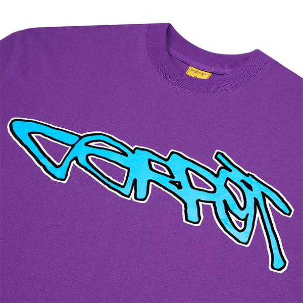 The CARPET CO. FREESTYLE TEE PURPLE by Carpet Co. is a purple cotton tee with a large blue and white graffiti-style "Carrot" logo across the chest.