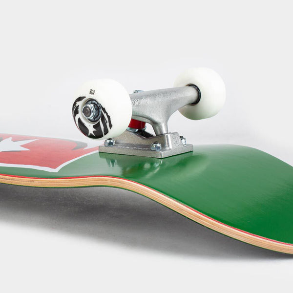 Close-up in BLACK & WHITE of a skateboard showing wheels, trucks, and the underside of the deck featuring a FOUNDATION STAR & MOON V 2.0 COMPLETE GREEN graphic.