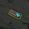 A black work shirt with a patch on it that says BLUETILE "HEART OF COLUMBIA" WORK SHIRT GREY by Bluetile Skateboards.