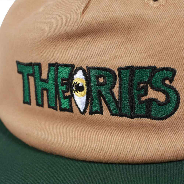 Beige THEORIES snapback with the word "theories" embroidered in green, featuring an eye design within the letter o.